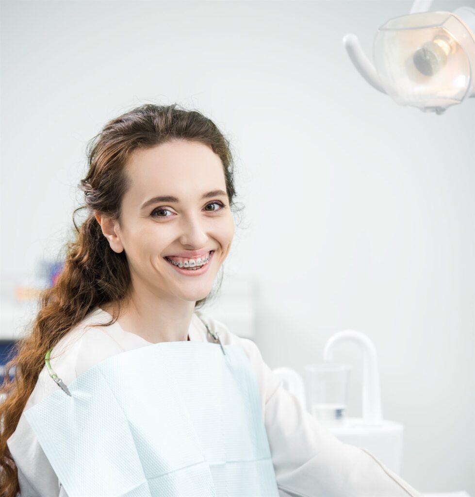 Patientin lächelt nach der Behandlung in einer modernen Zahnklinik